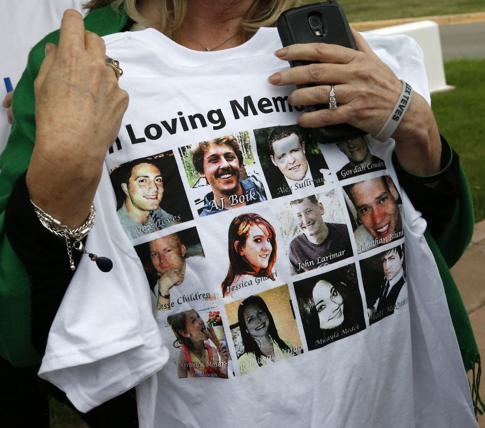 Sandy Phillips, whose daughter Jessica Ghawi was killed in the 2012 Aurora movie theater massacre, carries a T-shirt memorializing the 12 people killed in the attack, outside the Arapahoe County District Court.