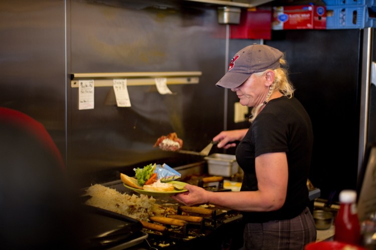 Darla Neugebauer, owner of Marcy’s Diner, works the grill Wednesday afternoon as she answers questions about the continued fallout from her reaction to a crying child at her restaurant last week.