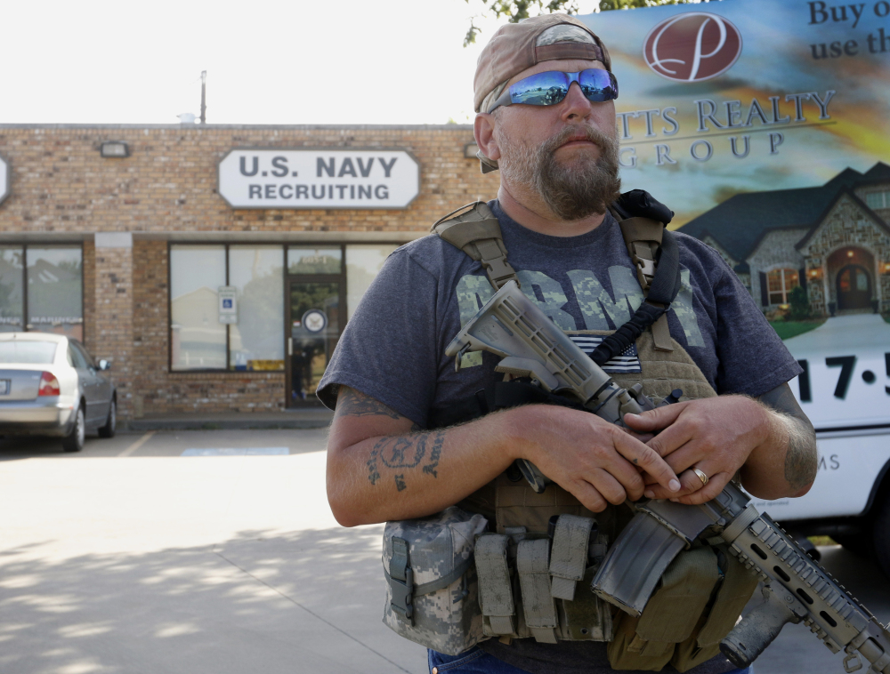Volunteer Terry Jackson stands guard outside a Navy recruiting station in Cleburne, Texas,