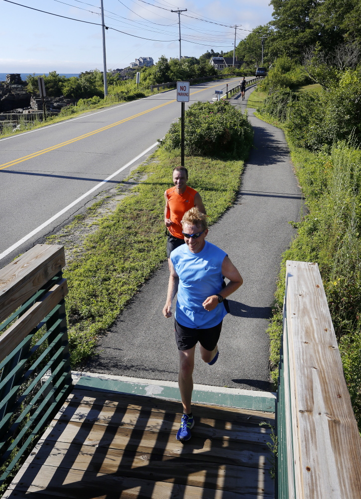 Al Swallow of South Portland, front, and Paul Letalien of Portland run along Shore Road in Cape Elizabeth while training for the 18th running of the TD Beach to Beacon 10K, which culminates farther up the road at Fort Williams Park.