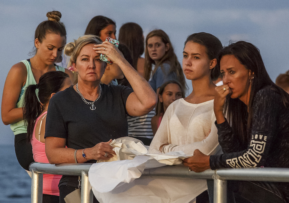 People gather during a candlelight vigil Monday for teenagers Austin Stephanos and Perry Cohen in Jupiter, Fla.