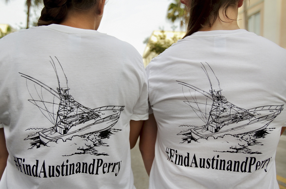 Girls wear T-shirts they bought to help fund a private search for two Florida teens who remain missing after their boat was found capsized at sea.