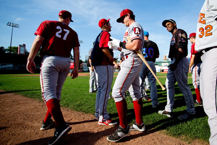 Dan Gamache of the Altoona Curve, center, takes off his batting gloves after winning the Home Run Derby before Wednesday's Eastern League All-Star Game at Hadlock Field.