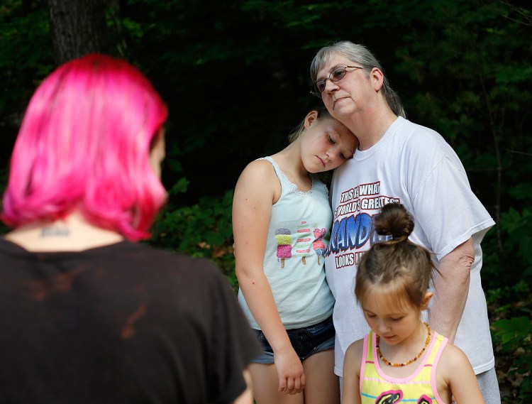 Jody Ingman of Standish comforts her granddaughter Delaney Walker, 10, who is visiting from Alaska. Police say an emergency call saying that someone had been fatally shot and that two people were being held hostage in their home Sunday evening was a hoax. 
Derek Davis/Staff Photographer