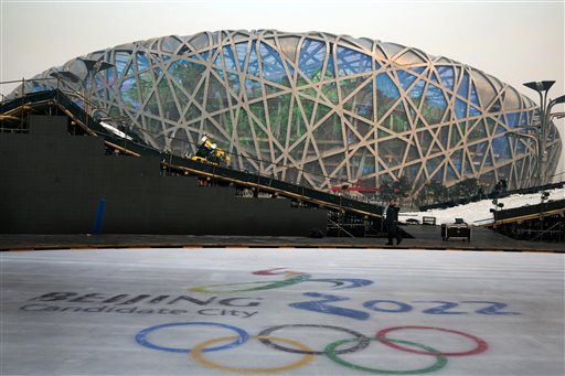 A worker walks past an ice rink with the logo for Beijing's Winter Olympics bid ahead of Friday's announcement that the Chinese capital  has been selected to host the event. The iconic Beijing National Stadium "Bird's Nest" stands in the background. The Associated Press