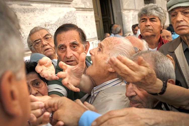 Pensioners try to get a number to enter a bank in Athens Wednesday. About 1,000 bank branches around the country were ordered by the government to reopen  to help desperate pensioners without ATM cards withdraw cash up to 120 euros ($134) from their retirement checks. The Associated Press


