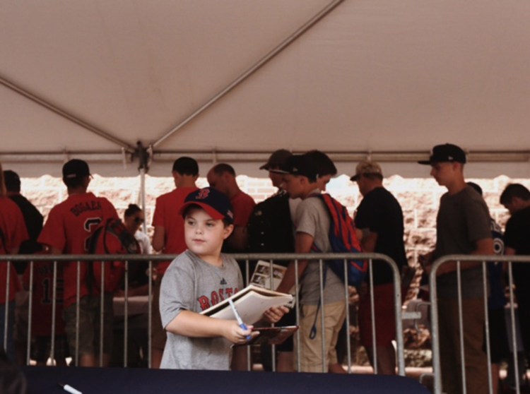 Kyle Hoffman, 8, holds a binder with baseball cards to be signed by players in the Eastern League All-Star game at Hadlock Field on Wednesday.