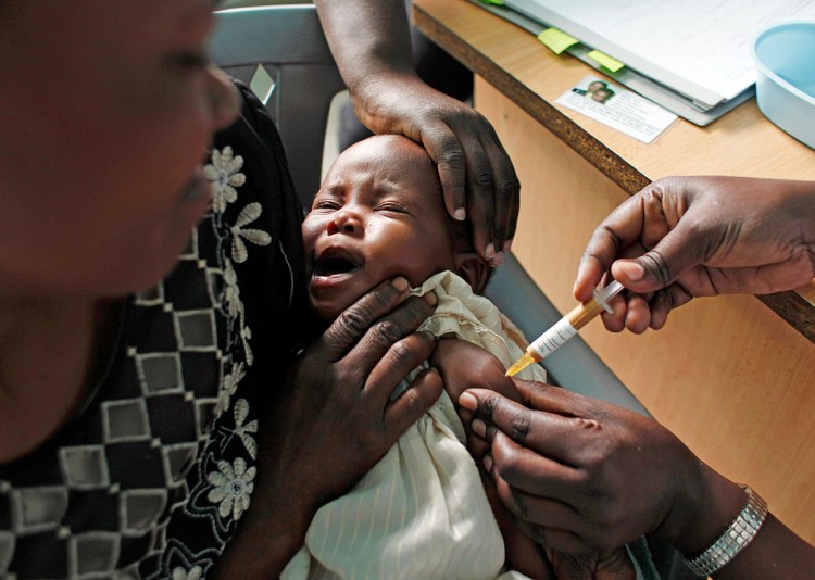 A mother holds her baby as she receives a new malaria vaccine as part of a trial at the Walter Reed Project Research Center in Kombewa in Western Kenya in 2009. The European Medicines Agency is recommending that the vaccine, known as Mosquirix, be licensed even though it is only about 30 percent effective and that protection fades over time. The Associated Press