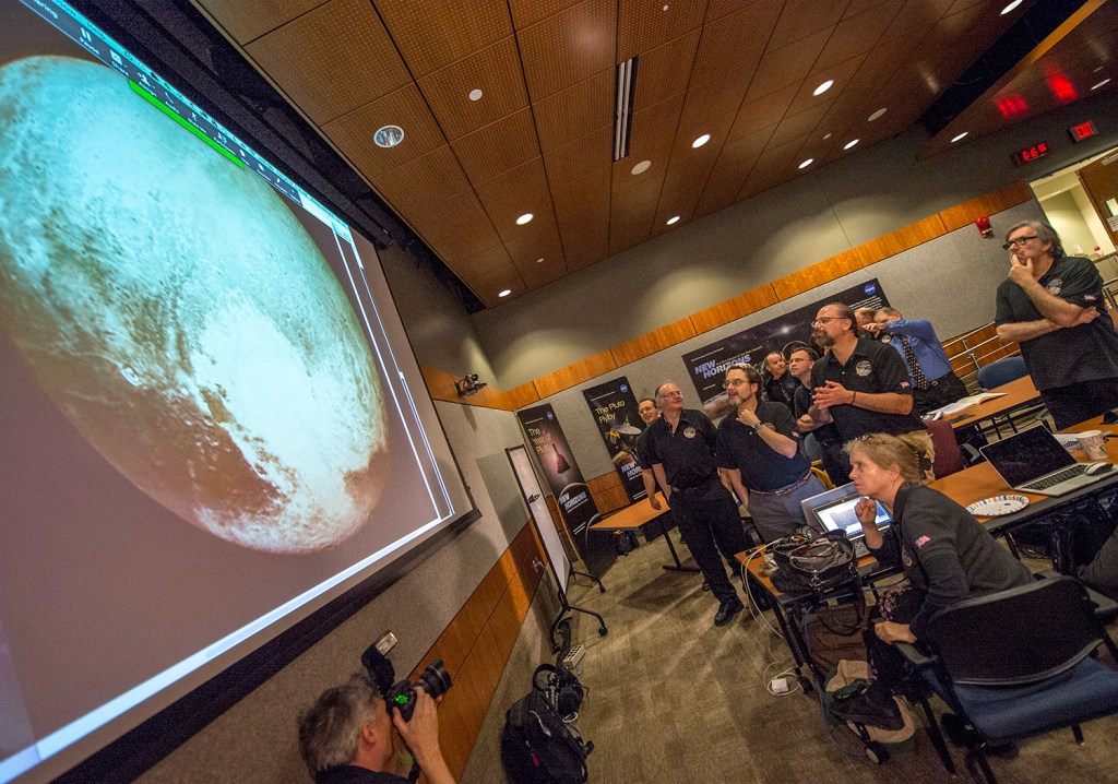 Members of the New Horizons science team react to seeing the spacecraft's last and sharpest image of Pluto before closest approach later in the day, Tuesday at the Johns Hopkins University Applied Physics Laboratory (APL) in Laurel, Maryland. The Associated Press