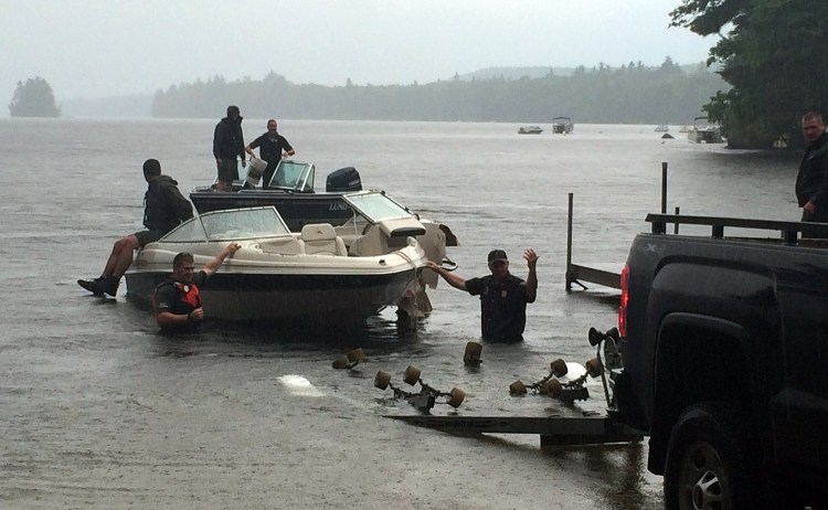 The Maine Warden Service removes one of the boats damaged in Thursday's crash out of Thompson Lake at the public boat launch in Otisfield.