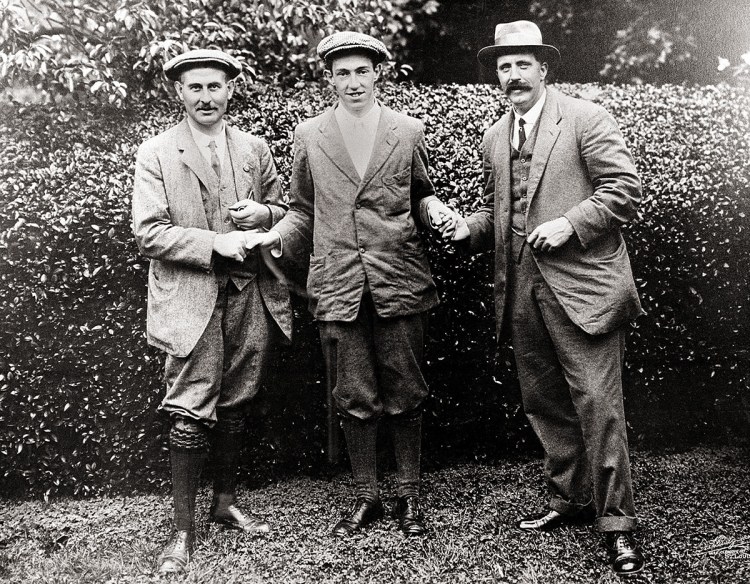In this 1913 photo, American golfer Francis D. Ouimet, center, shakes hands with Harry Vardon, left, and Ted Ray, both of Britain, at the U.S. Open golf tournament at The Country Club in Brookline, Mass. The Country Club is where Ouimet won a playoff over Vardon and Ray. The upset put golf on the front pages of newspapers. 