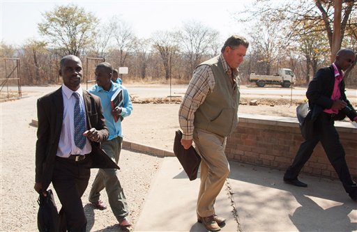 Theodro Bronkhorst, center, a professional hunter, arrives at the magistrates courts in Hwange, Zimbabwe, Wednesday. Bronkhorst has been charged with  failure to prevent an unlawful hunt that resulted in the killing of Cecil the lion by Minnesota dentist, Walter James Palmer. The Associated Press