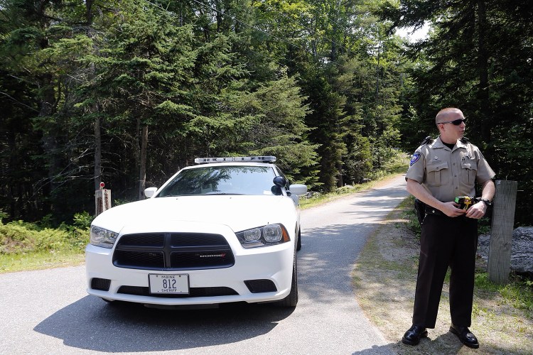 Deputy Chubbuck of the Lincoln County Sheriff's Department stands by the entrance to the residence on Lakeside Drive. Derek Davis/Staff Photographer