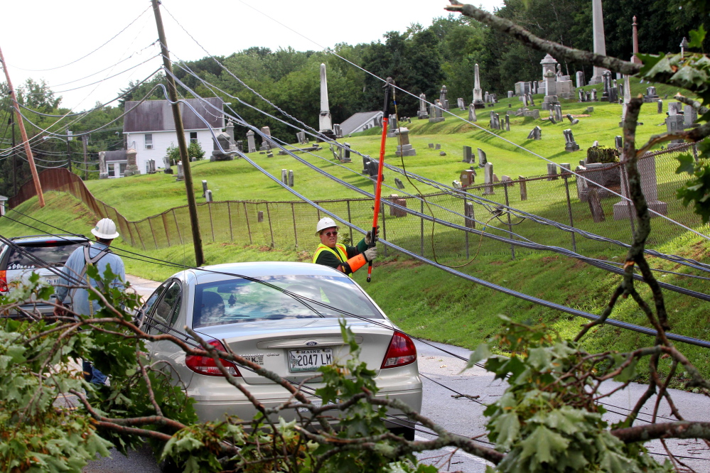 Central Maine Power Co. crewman Wayne Piper installs a ground wire Saturday on Morton Street in Winthrop so a tree crew can safely remove limbs that took out power lines during a thunderstorm that afternoon, and caused the temporary closure of the street.