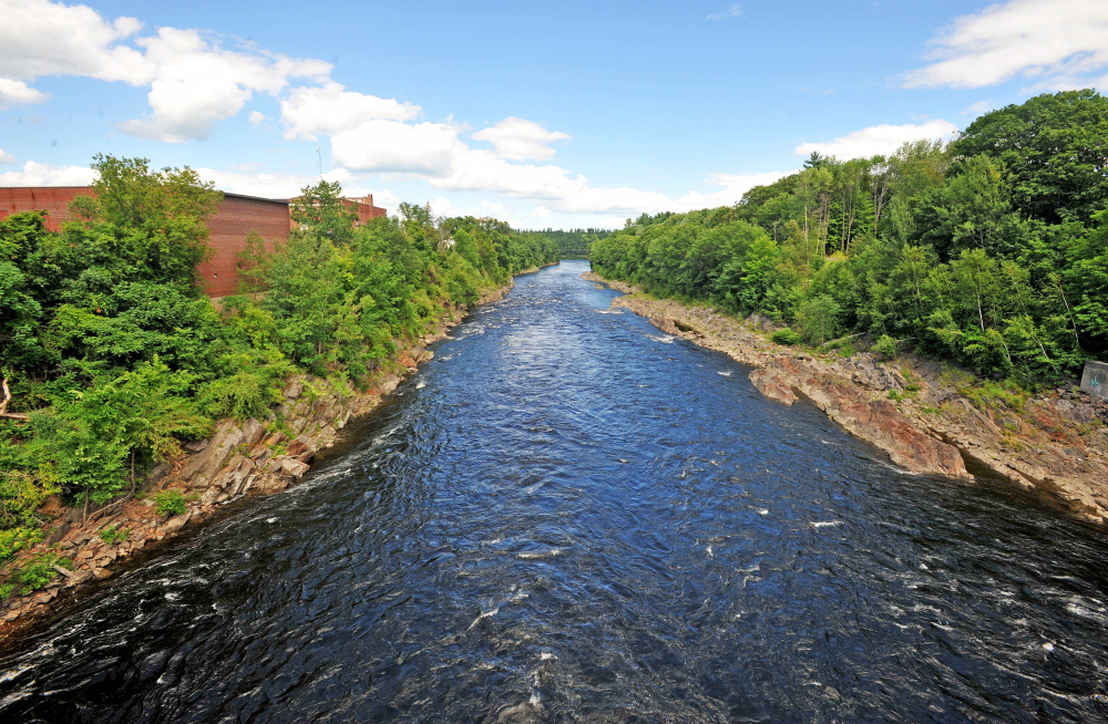 A section of the Kennebec River flows under the footbridge below the Weston Dam, where a rail road trestle used to be but collapsed in the flood of April 1987. The railroad bridge wreckage must be removed before the whitewater park planned for the river can be built.
