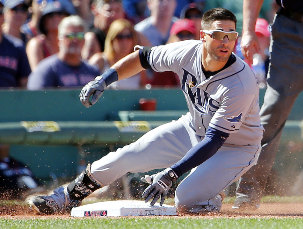 Tampa Bay Rays' Kevin Kiermaier slides into third base with a triple against the Boston Red Sox during the seventh inning of a baseball game at Fenway Park in Boston, Sunday, Aug. 2, 2015. (AP Photo/Winslow Townson)