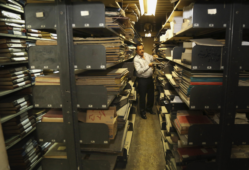 A library staffer works at the Baghdad National Library in Iraq. Librarians and academics in Baghdad are working to preserve what’s left after thousands of documents were lost or damaged at the height of the U.S.-led invasion.