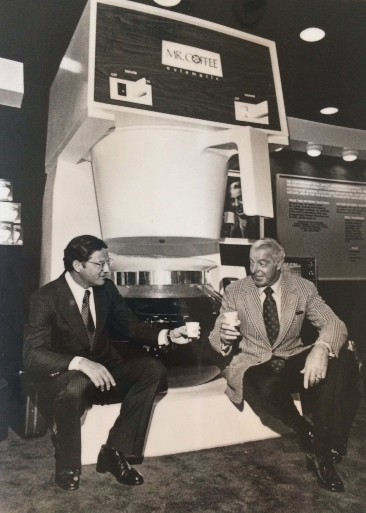 This 1977 photo provided by the Marotta family shows Vincent Marotta, left, and Joe DiMaggio sitting on a large Mr. Coffee machine in Chicago.