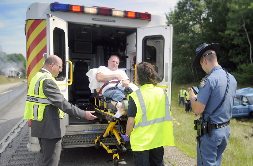 State Police and medics load Trooper Greg Stevens into an ambulance Thursday after his cruiser was struck by a tractor-trailer in the northbound lane of Interstate 295 in Richmond.