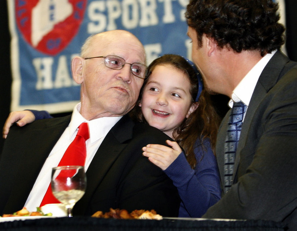 Maine Sports Hall of Fame inductee Harold “Tank” Violette receives a hug from his granddaughter, Allison Hegarty, during the Maine Sports Hall of Fame awards banquet on May 22, 2011, at the Augusta Civic Center. Violette died Tuesday
