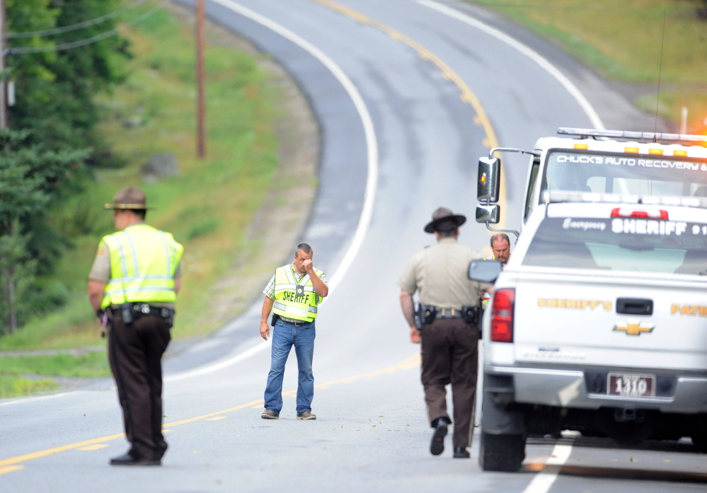 Police converge on the scene on U.S. Route 201 in West Forks Plantation after the wreckage of a double fatal accident was found Tuesday afternoon. Police said Martin Poulin and Francine Dumas crossed into the United States at Jackman Station, about 35 miles north of the accident scene, a week before the accident was discovered.
