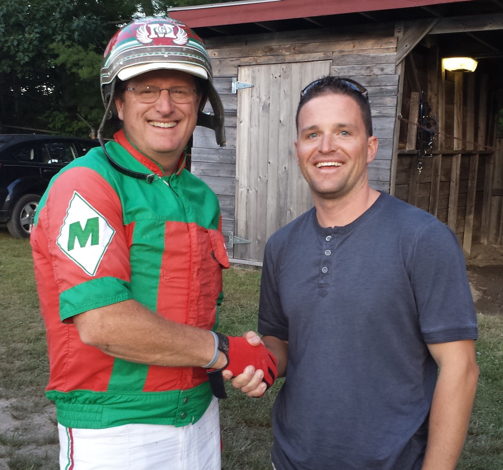 Contributed photo/MHHA 
 Yannick Gingras, right, congratulates Gary Mosher in the paddock of the Topsham Fairgrounds on Tuesday after Mosher won his 6,000th career race.