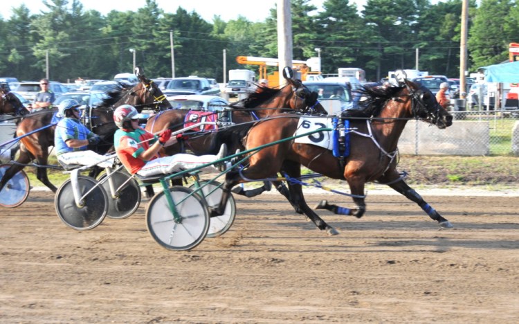 Contributed photo/Shelley Gilpatrick 
 Gary Mosher, riding So What Who Cares, crosses the finish line at the Topsham Fairgrounds on Tuesday to win his 6,000th career race.