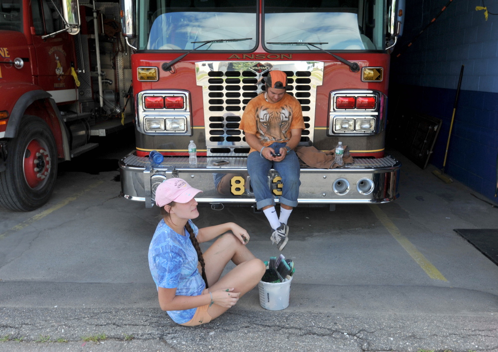 Charlie Grim, 23, and Luke Pukanecz, 17, take a break Thursday after a day of painting the North Anson Fire Station.