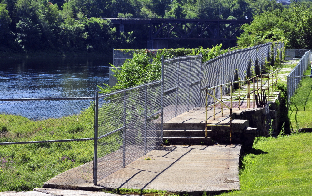 This 8-foot-high chain-link fence between Mill Park and the Kennebec River, seen Saturday in Augusta, might be replaced by a more attractive and shorter one. The City Council plans to discuss that idea and other capital improvement projects Monday, including building a mile-long looped walking path around the park’s perimeter.