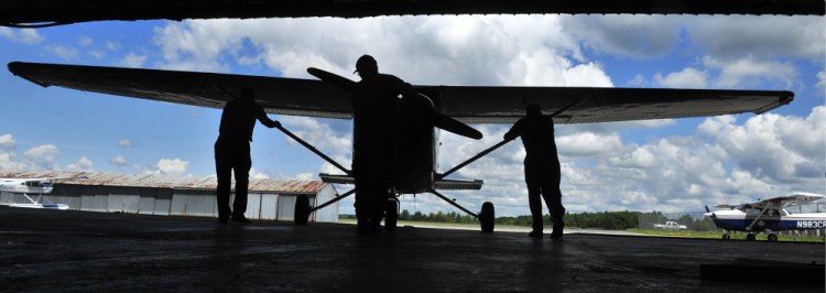 Civil Air Patrol senior members push a plane out of the group’s hangar Saturday at the Augusta State Airport. Two pilots were going to use the plane to look for forest fires.