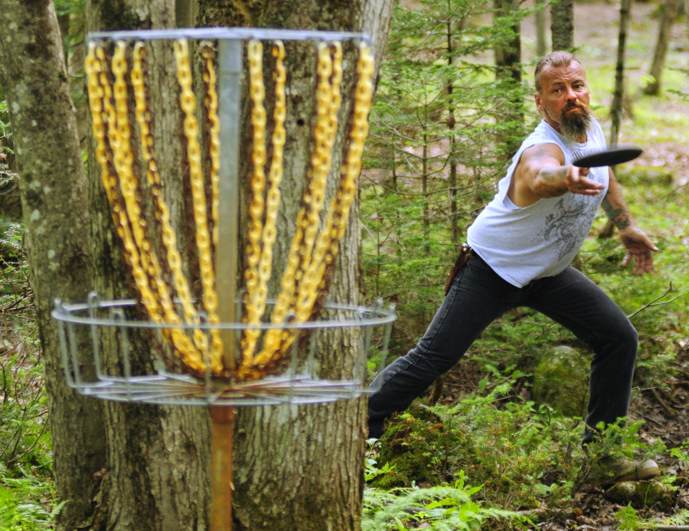 Charlie Wilson throws towards the basket while playing the short nine hole putt course at DND Disc Golf on Thursday in Sidney.