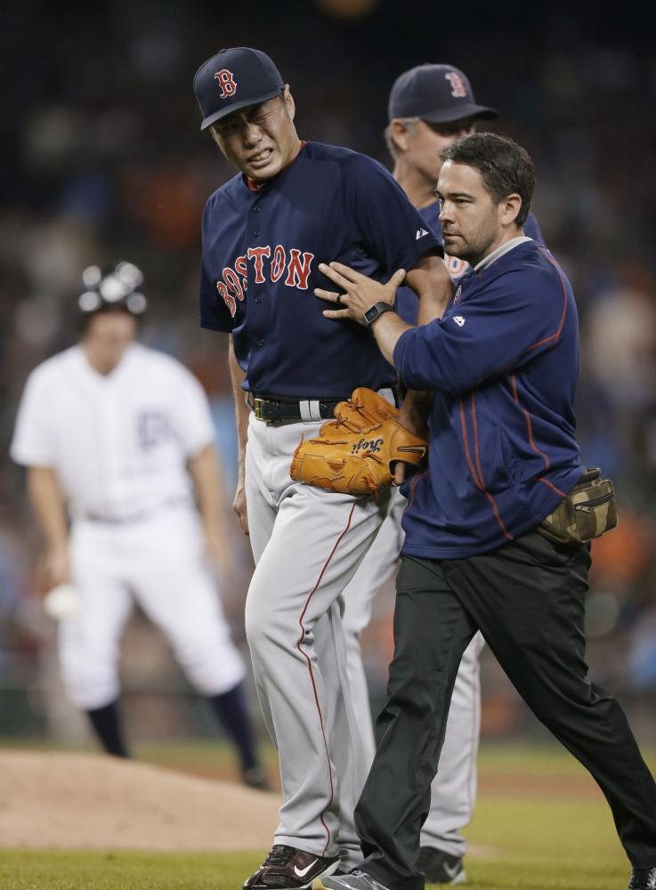Boston Red Sox relief pitcher Koji Uehara is helped off the field after a game against the Detroit Tigers last week in Detroit. Uehara is out for the rest of the season with a broken wrist.