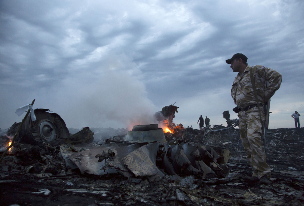 In this July 17, 2014 file photo people walk amongst the debris, at the crash site of a passenger plane near the village of Grabovo, Ukraine.