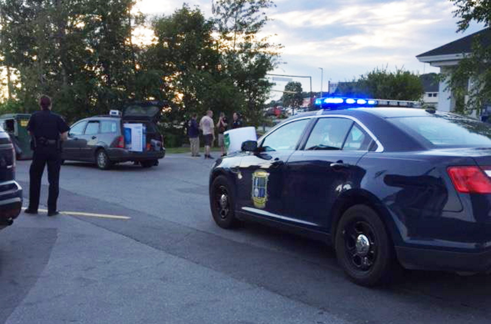 Police gather in the Big Apple parking lot as an alleged Wal-Mart shoplifter is arrested Monday night. Noah Herrin, 29, a transient from Lewiston, allegedly stole a big screen TV, seen in the open hatchback of the car in the background, from an Augusta Wal-Mart.