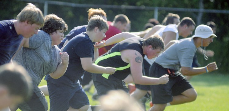 The Gardiner Area High School football team sprint during practice Monday in Gardiner.