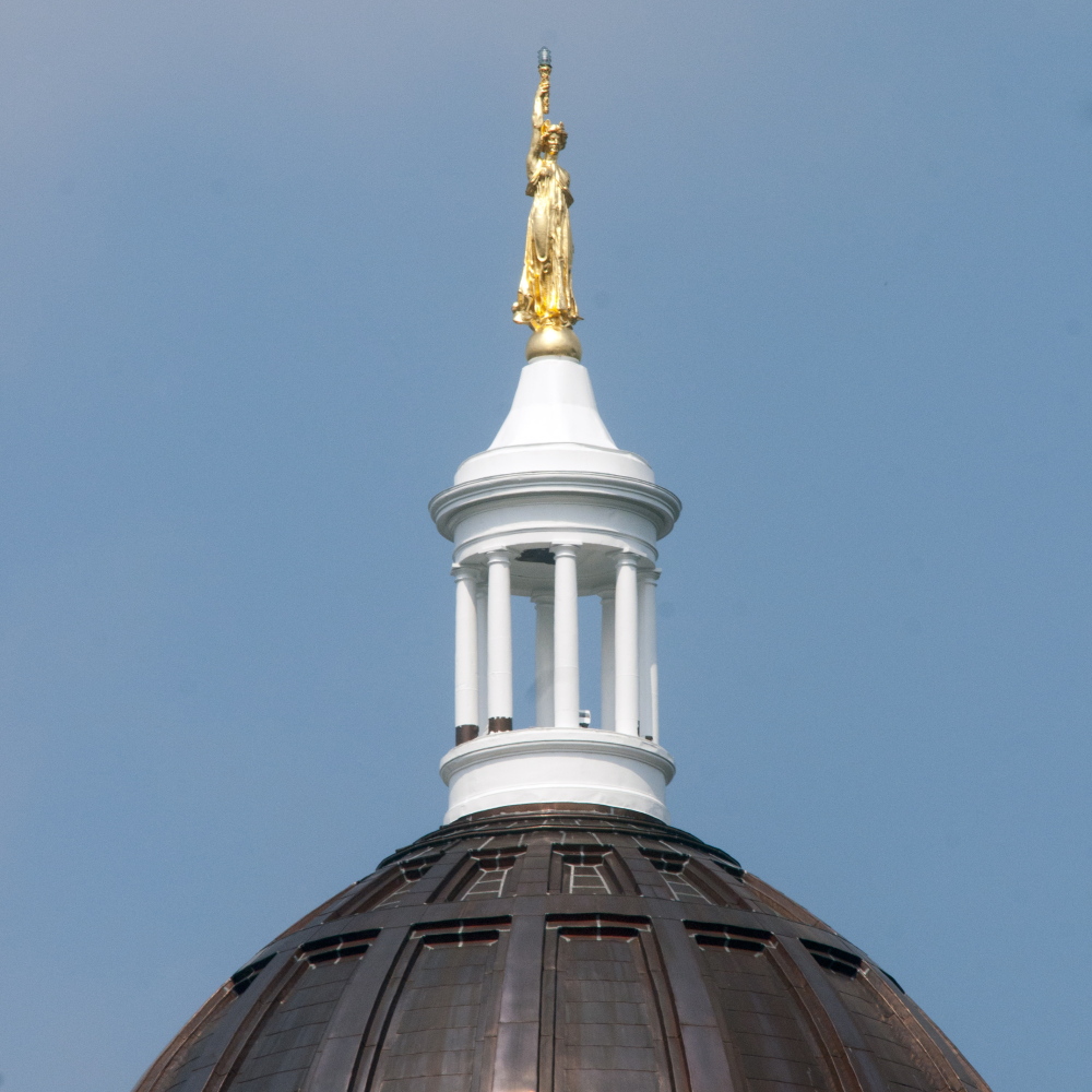 Peeling paint on the pillars around the State House dome in Augusta can be seen Wednesday.