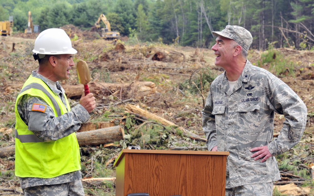 Lt. Col. Norm Michaud, project manager, jokes about using a smaller shovel, before Brig. Gen. Gerard Bolduc, adjutant general of Maine National Guard, used a large excavator during a ceremonial ground breaking for new headquarters on Thursday in Augusta.
