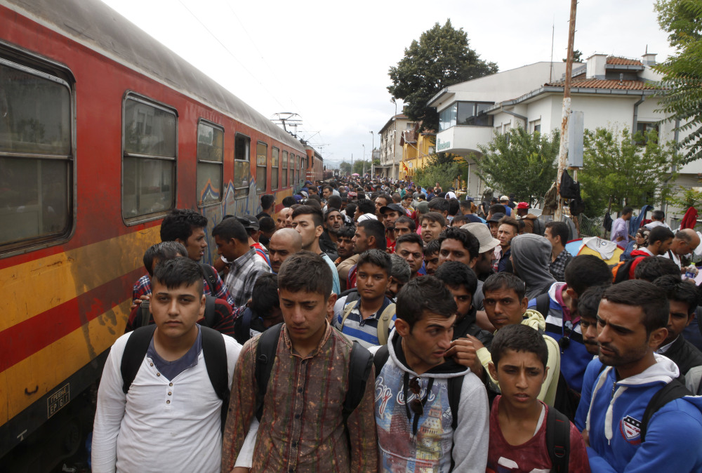 Migrants line up to board a train that will take them toward Serbia, at the railway station in the southern Macedonia’s town of Gevgelija on Saturday.