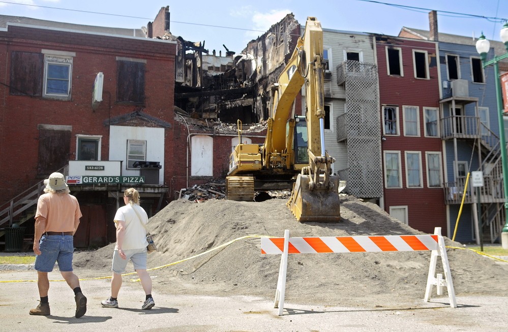Four days after the July 16 fire, people view the damage from the back side of Water Street buildings in Gardiner.