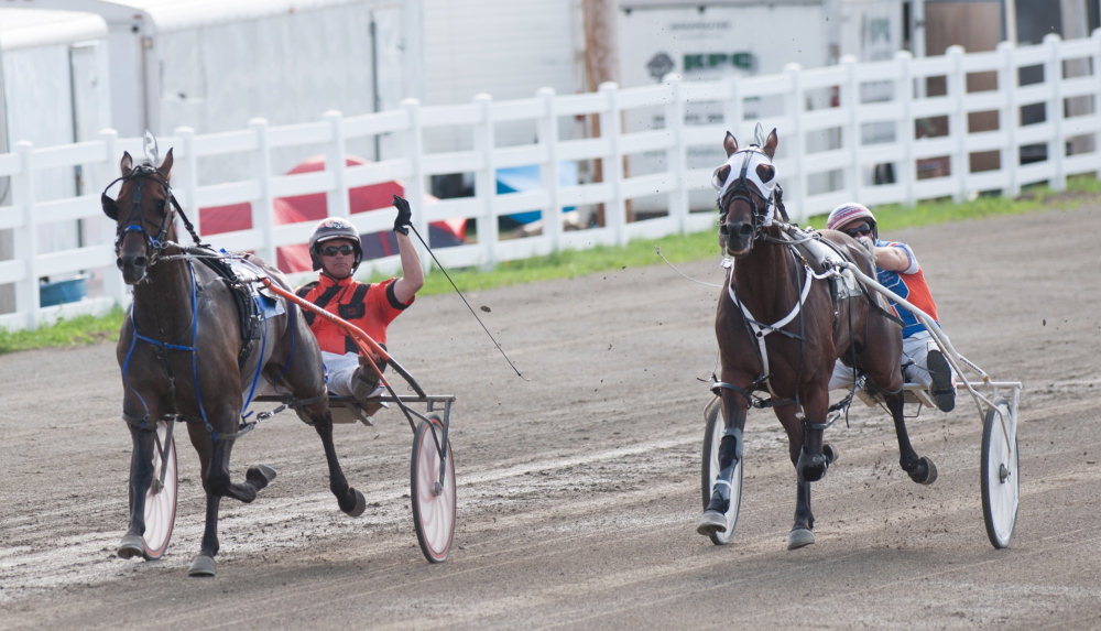 Kevin Bennett photo 
 Heath Campbell, left, riding Wheelaway, crosses the finish line ahead of Warrawee Nonsuch and driver David Ingraham on Saturday to win the annual Walter H. Hight Invitational at the Skowhegan Fairgrounds.