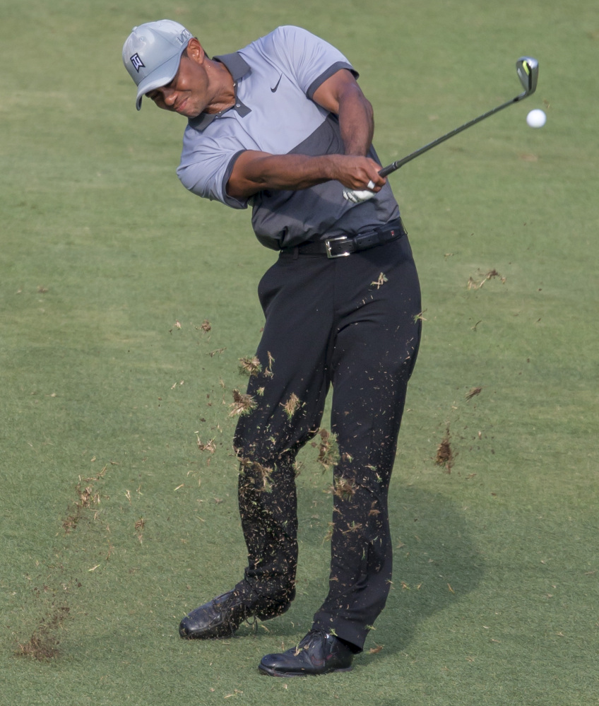 AP photo 
 Tiger Woods hits from the fairway to the 18th green during the third round of the Wyndham Championship at Sedgefield Country Club in Greensboro, N.C., on Saturday.