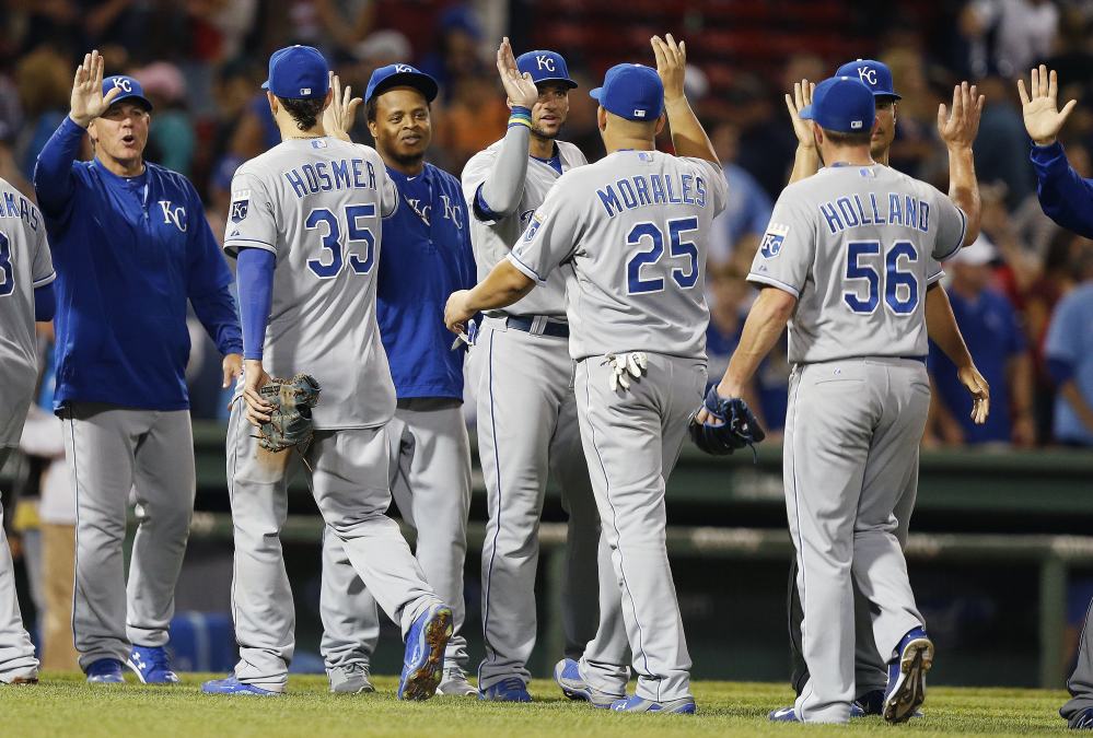 AP photo 
 The Kansas City Royals, including Greg Holland (56), Kendrys Morales (25) and Eric Hosmer (35), celebrate after defeating the Boston Red Sox 6-3 on Saturday.