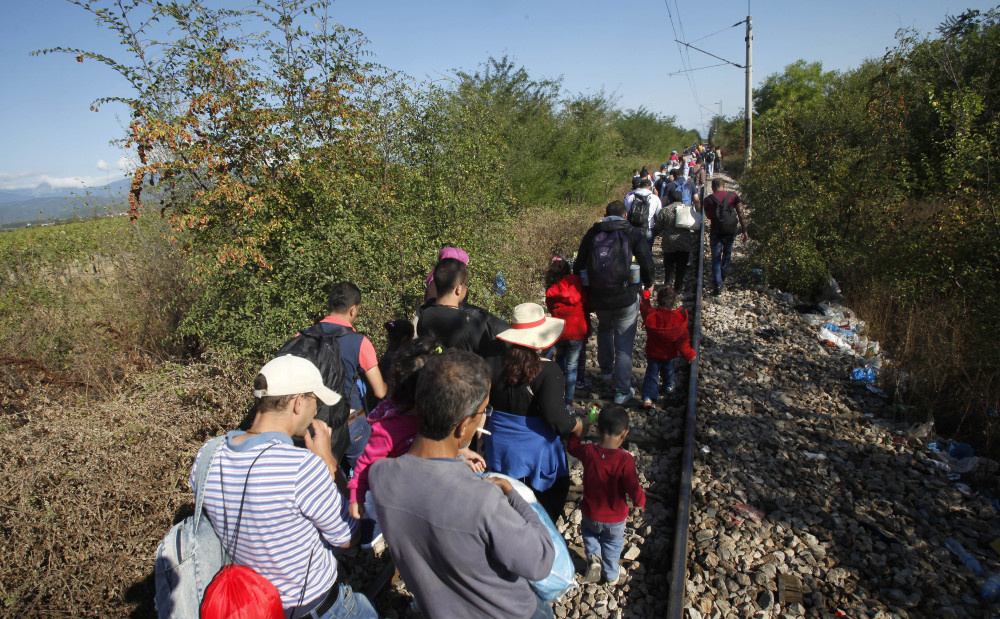 Migrants walk along the railway tracks after crossing from Greece to Macedonia, at the border line between the two countries, near southern Macedonia’s town of Gevgelija on Sunday.