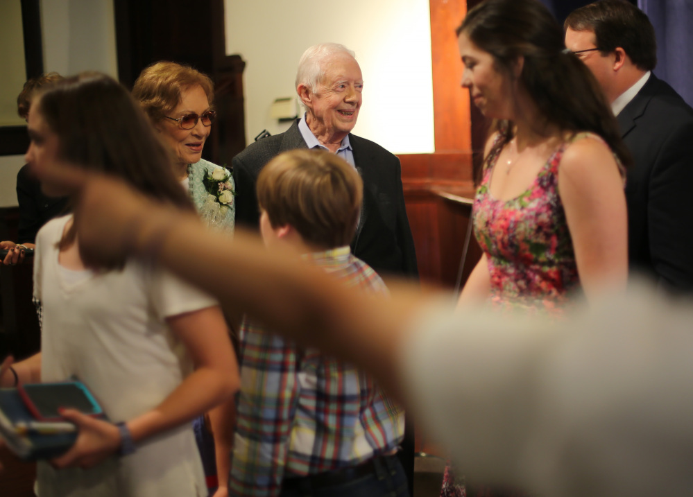 Former President Jimmy Carter, center, and Rosalynn Carter greet the visitors who attended the Sunday school he taught Sunday morning in Plains, Georgia.
