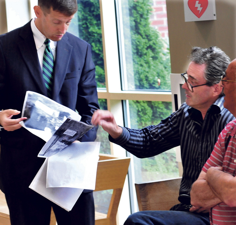 Robert Dale, right, points to images of his Fairfield business clean-up efforts to attorney Walter McKee prior to a hearing in Skowhegan District Court on Monday.