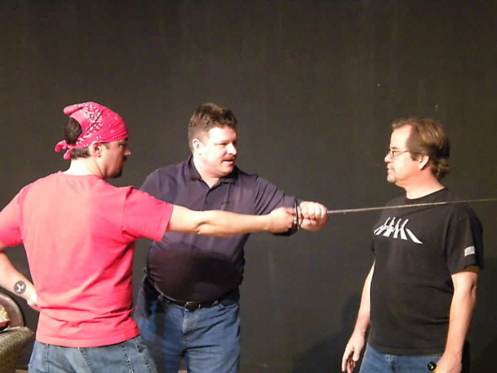 Instructor Jeffrey Eagen, center, shows actors James Paine, left, and Bart Shattuck, right, proper combat technique during training for the Aqua City Actors Theater.