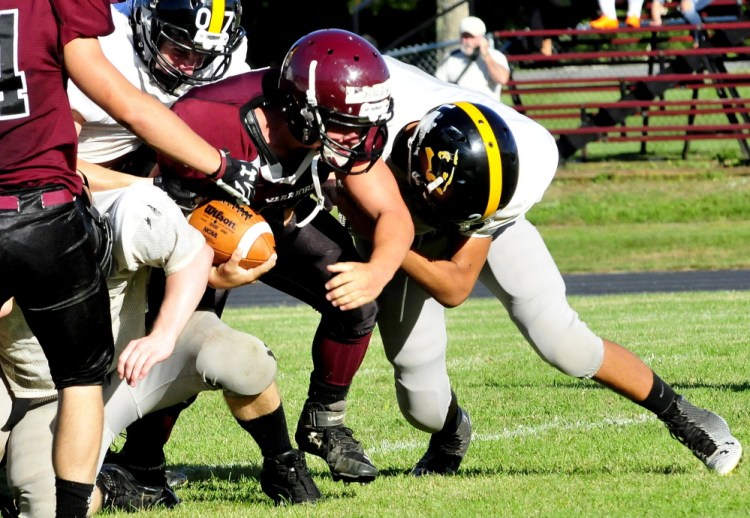 Staff photo by David Leaming 
 Nokomis' Cody Rice gets sacked by a Maranacook defender during a scrimmage in Newport on Monday.