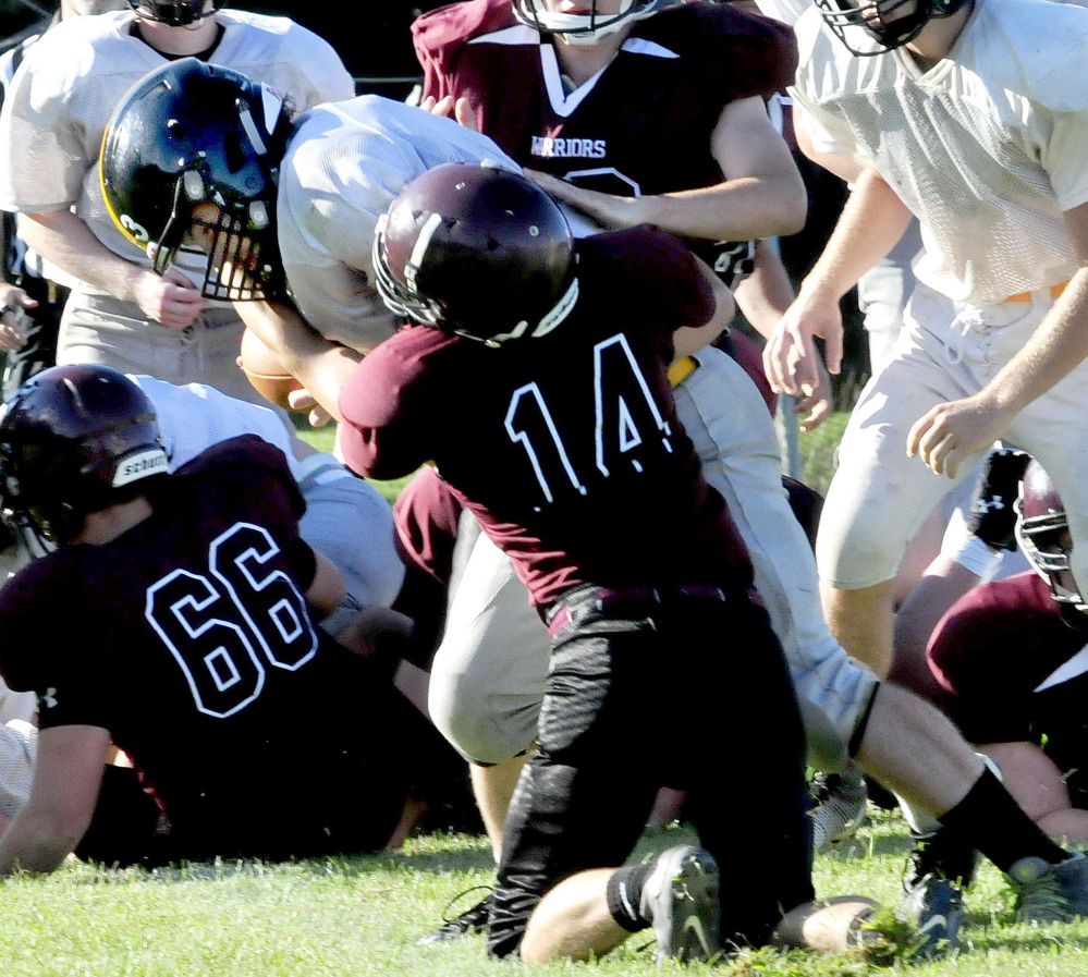 Staff photo by David Leaming 
 Maranacook quarterback Kyle Morand evades a tackle by Nokomis' Isaac Thibodeau during a scrimmage in Newport on Monday.