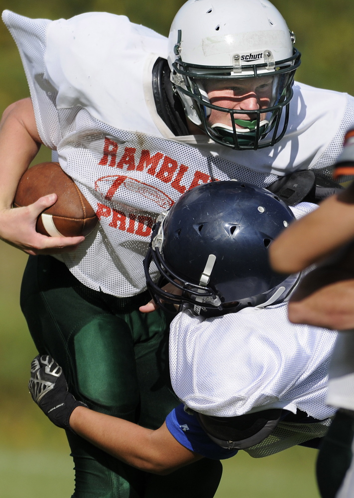 Staff photo by Andy Molloy 
 Winthrop High School quarterback Matt Ingram runs through a tackle during a scrimmage against Lincoln on Monday.