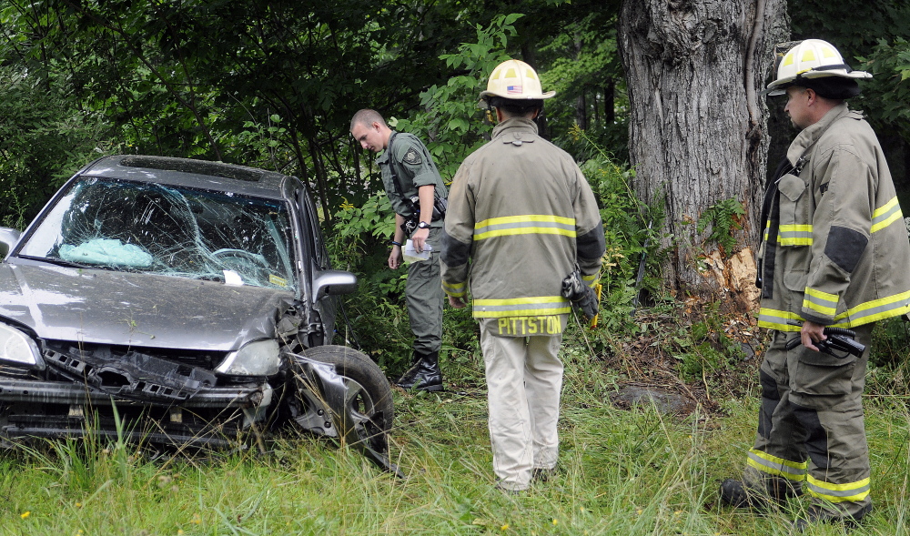 Police and firefighters examine the scene of an accident on Route 194 in Pittston that injured a teenage driver on Tuesday.